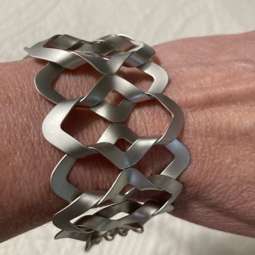 Handcrafted metal statement bracelet with lobster clasp.
